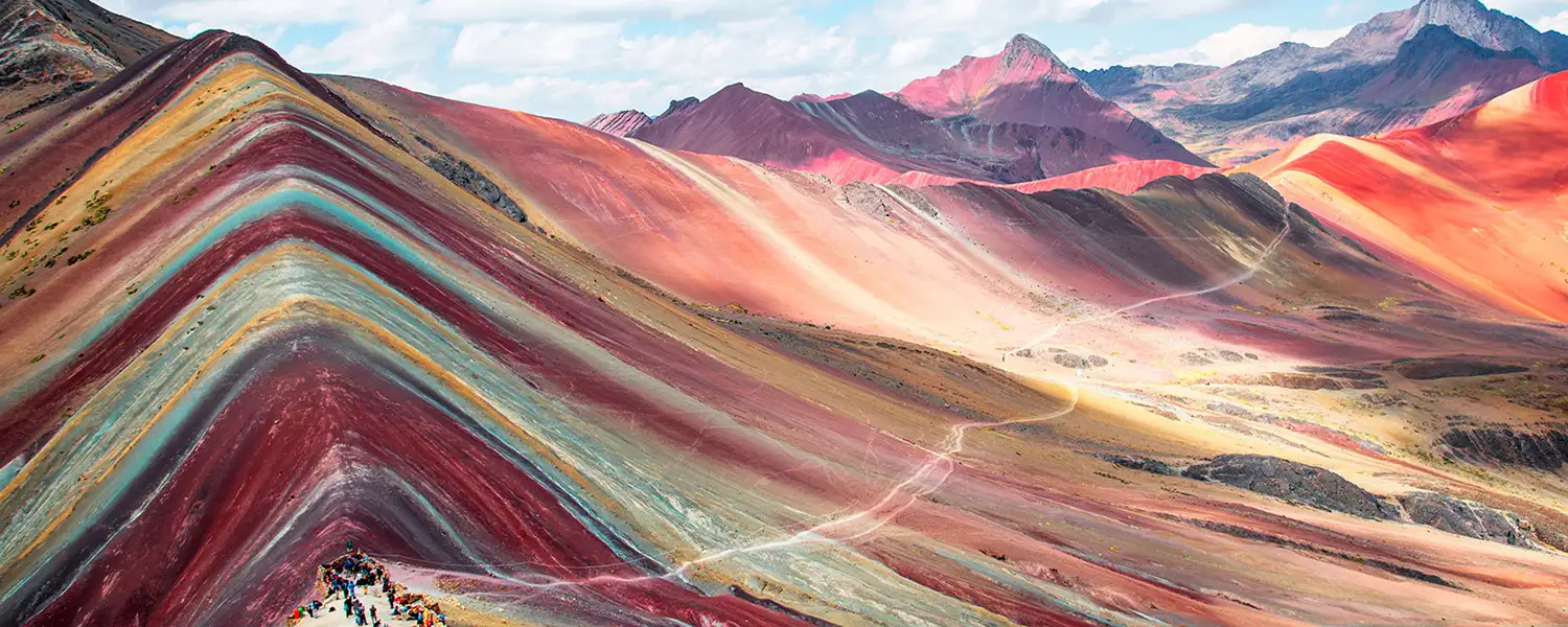 Tourist jumping for joy in Vinicunca